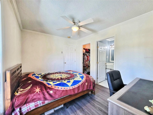 bedroom featuring a spacious closet, ornamental molding, and wood finished floors