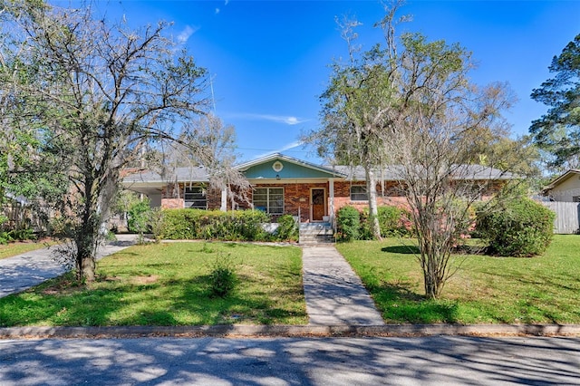 view of front of home featuring a front yard, concrete driveway, fence, and brick siding