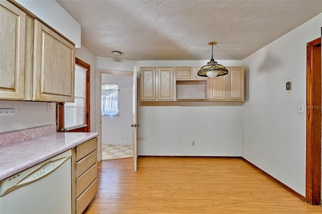 kitchen featuring white dishwasher, baseboards, light wood-style floors, and light brown cabinets