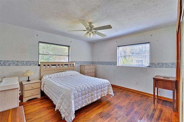 bedroom with multiple windows, a textured ceiling, and hardwood / wood-style flooring