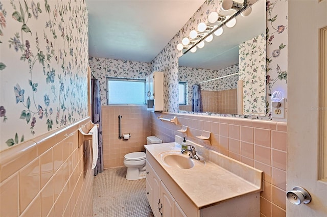 full bathroom with wallpapered walls, tile walls, tile patterned flooring, and wainscoting