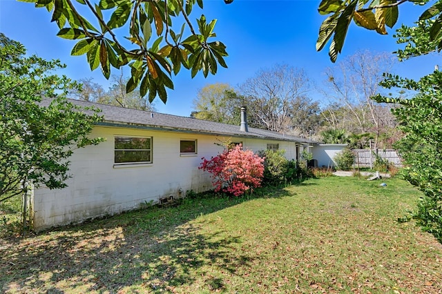 view of side of property featuring a yard and fence