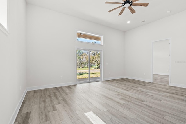 empty room with visible vents, a ceiling fan, light wood-type flooring, and baseboards