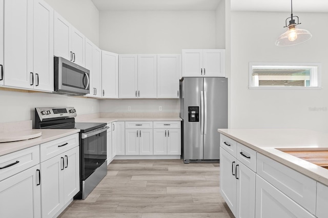 kitchen featuring appliances with stainless steel finishes, white cabinetry, light countertops, and light wood-style floors