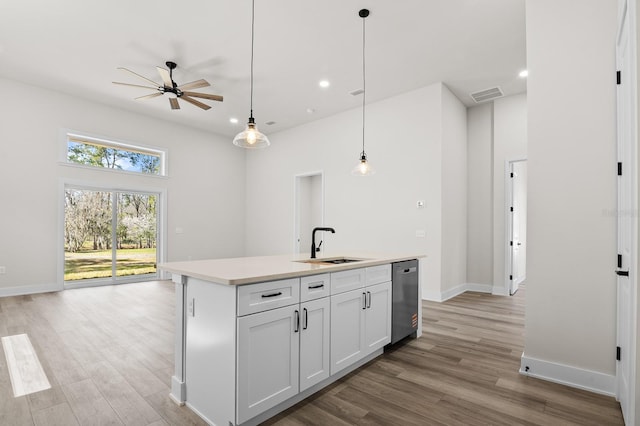 kitchen with visible vents, a sink, light countertops, light wood-style floors, and pendant lighting