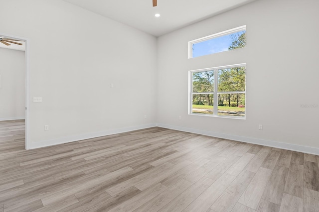 spare room featuring recessed lighting, baseboards, a ceiling fan, and light wood finished floors