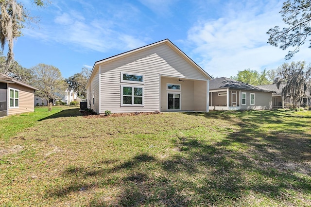 rear view of property featuring a lawn, central AC unit, and a ceiling fan