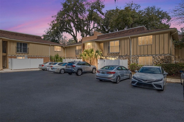 view of front of property featuring uncovered parking and stone siding