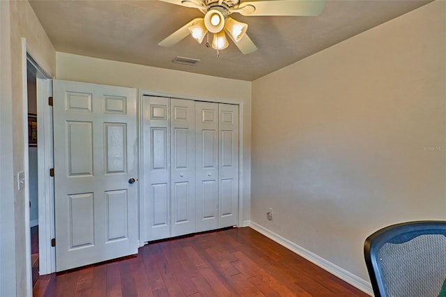 interior space featuring visible vents, dark wood finished floors, a closet, baseboards, and ceiling fan