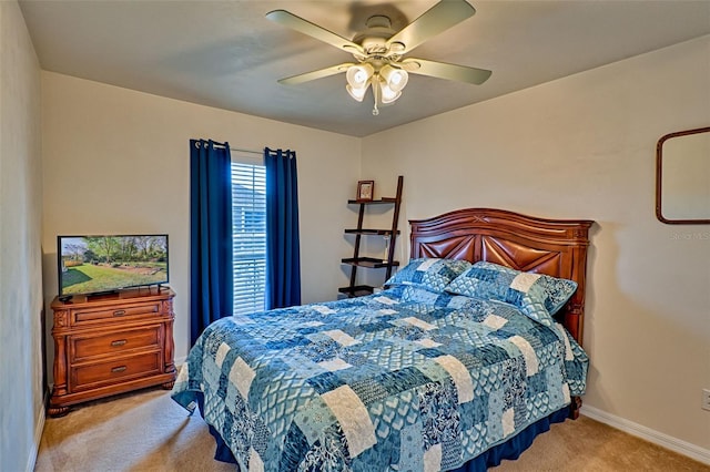 bedroom featuring baseboards, light colored carpet, and a ceiling fan