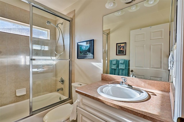 full bathroom featuring combined bath / shower with glass door, toilet, and vanity