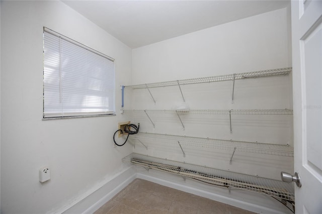 laundry room with tile patterned floors, laundry area, baseboards, and washer hookup