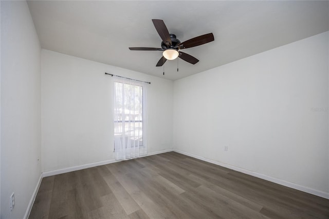 empty room featuring baseboards, a ceiling fan, and wood finished floors