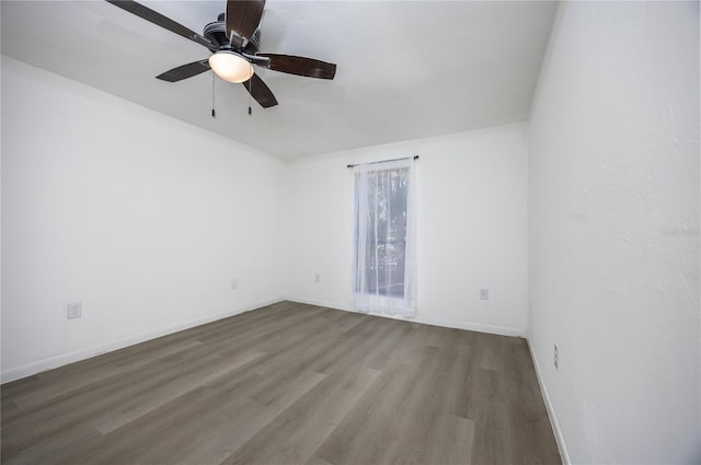 unfurnished room featuring a ceiling fan, wood finished floors, and baseboards