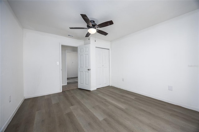 unfurnished bedroom with visible vents, baseboards, wood finished floors, a closet, and a ceiling fan