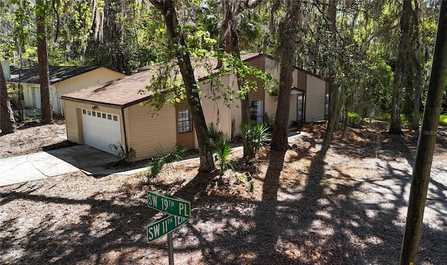 view of home's exterior featuring roof with shingles, concrete driveway, and an attached garage