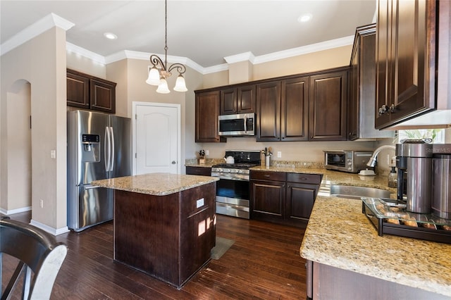 kitchen featuring dark brown cabinets, light stone countertops, dark wood finished floors, stainless steel appliances, and a sink