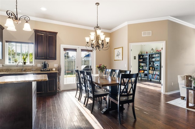 dining area with visible vents, dark wood-type flooring, a notable chandelier, and crown molding