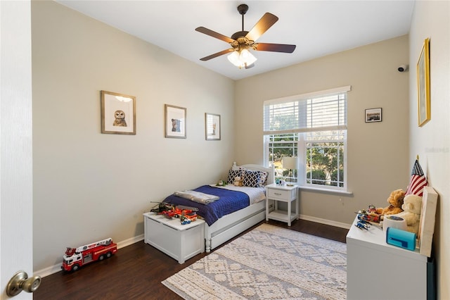 bedroom featuring ceiling fan, baseboards, and wood finished floors