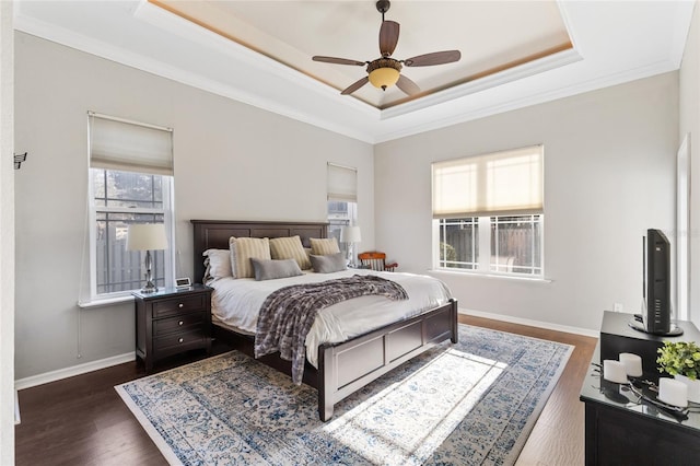 bedroom with crown molding, a raised ceiling, baseboards, and dark wood-style flooring