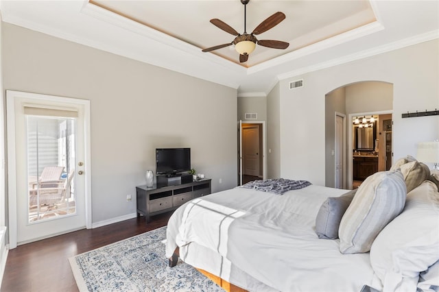 bedroom with visible vents, arched walkways, dark wood-style flooring, crown molding, and a raised ceiling