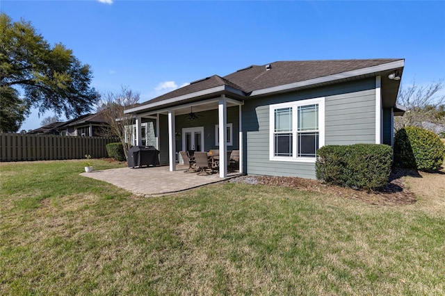 back of house featuring a shingled roof, ceiling fan, fence, a yard, and a patio area