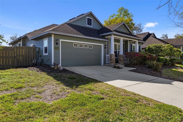 view of front of home with a front yard, fence, driveway, a porch, and an attached garage