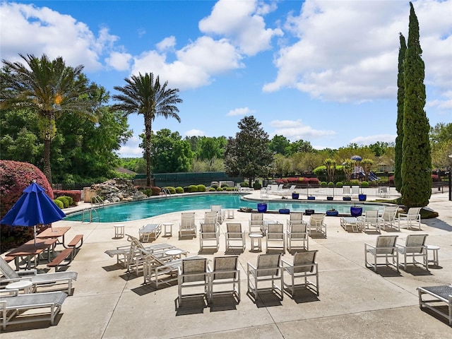 pool with a patio area and fence