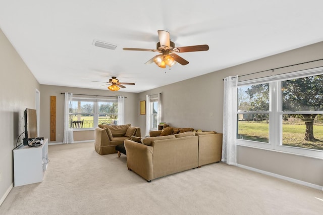 living area featuring visible vents, baseboards, light colored carpet, and ceiling fan