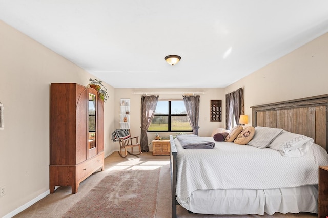 bedroom with light colored carpet and baseboards