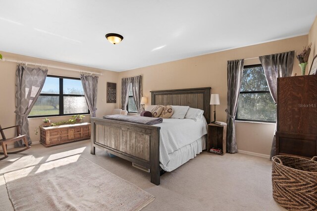 bedroom featuring light colored carpet and baseboards