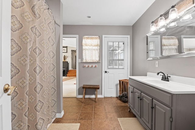 full bath featuring baseboards, vanity, and tile patterned flooring