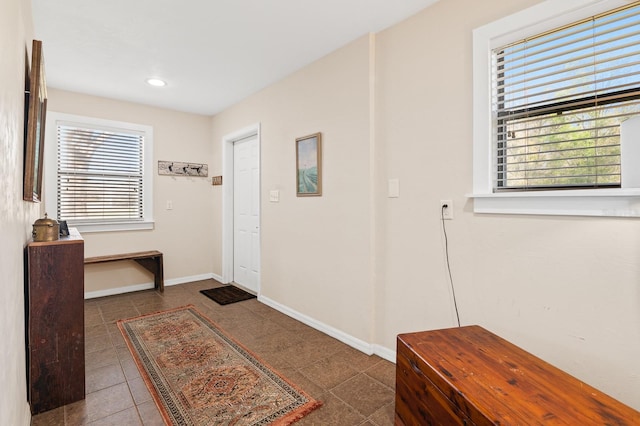 tiled entryway featuring recessed lighting and baseboards