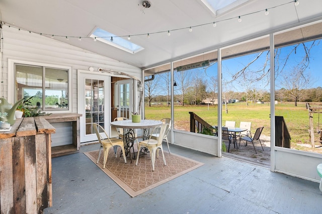 sunroom / solarium featuring lofted ceiling with skylight