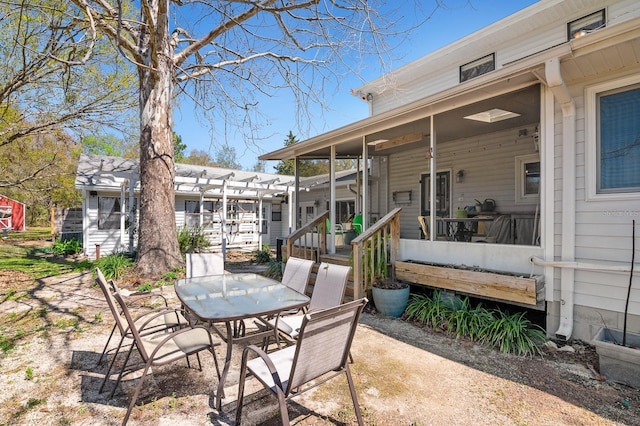 view of patio with outdoor dining space, a pergola, and a sunroom