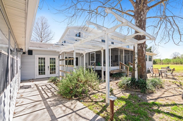 back of property featuring a patio area, french doors, and a sunroom