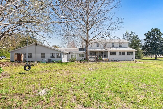 rear view of property with a lawn