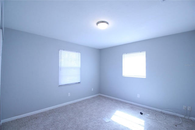 empty room featuring carpet flooring and baseboards