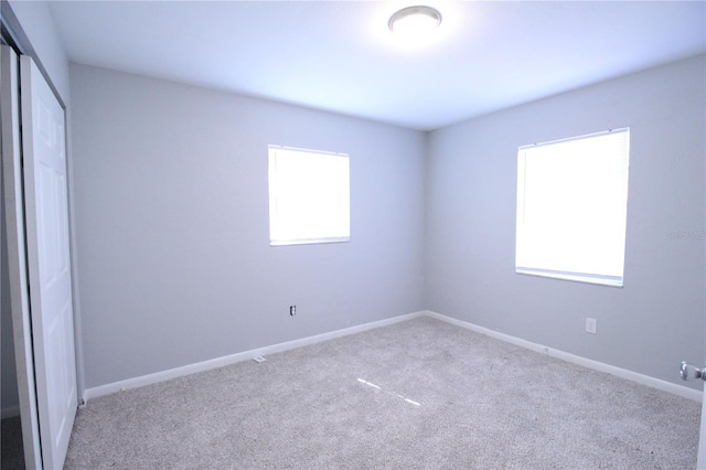 unfurnished bedroom with carpet flooring, baseboards, and a closet