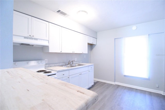 kitchen with visible vents, under cabinet range hood, a sink, white electric stove, and light countertops