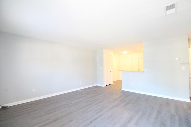 spare room with visible vents, baseboards, and wood finished floors