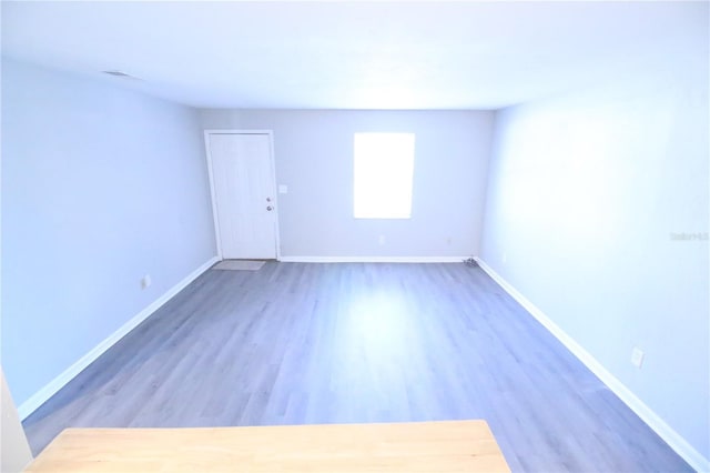 empty room featuring baseboards and wood finished floors