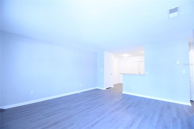 empty room with visible vents, wood finished floors, and baseboards