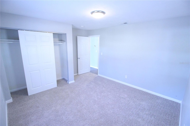 unfurnished bedroom with a closet, baseboards, and carpet floors