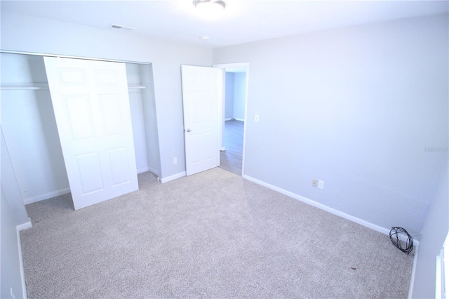 unfurnished bedroom with baseboards, visible vents, carpet floors, and a closet