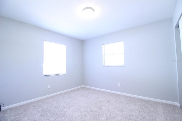 carpeted spare room with baseboards