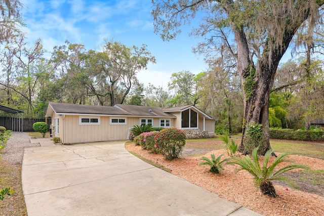 view of front facade with driveway and fence