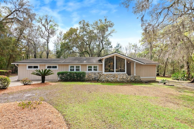 exterior space featuring stone siding and a front lawn