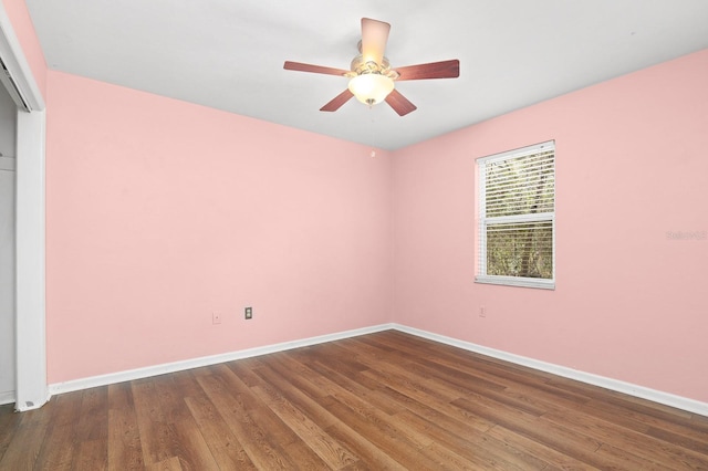 unfurnished room with ceiling fan, baseboards, and wood finished floors