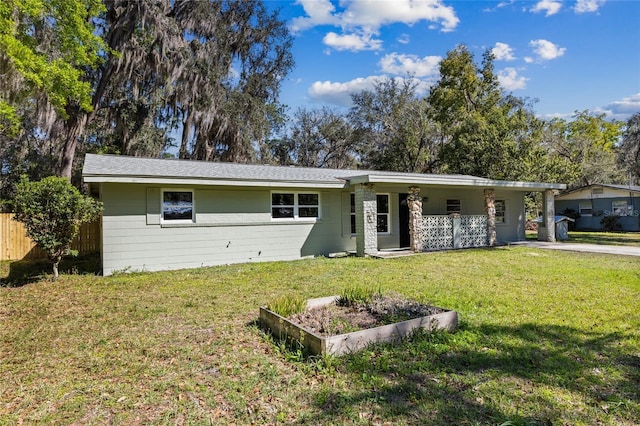 ranch-style home featuring a front lawn and fence